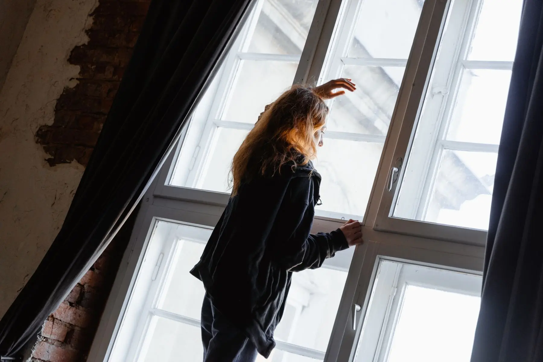 Nachdenkliche Frau am großen Fenster