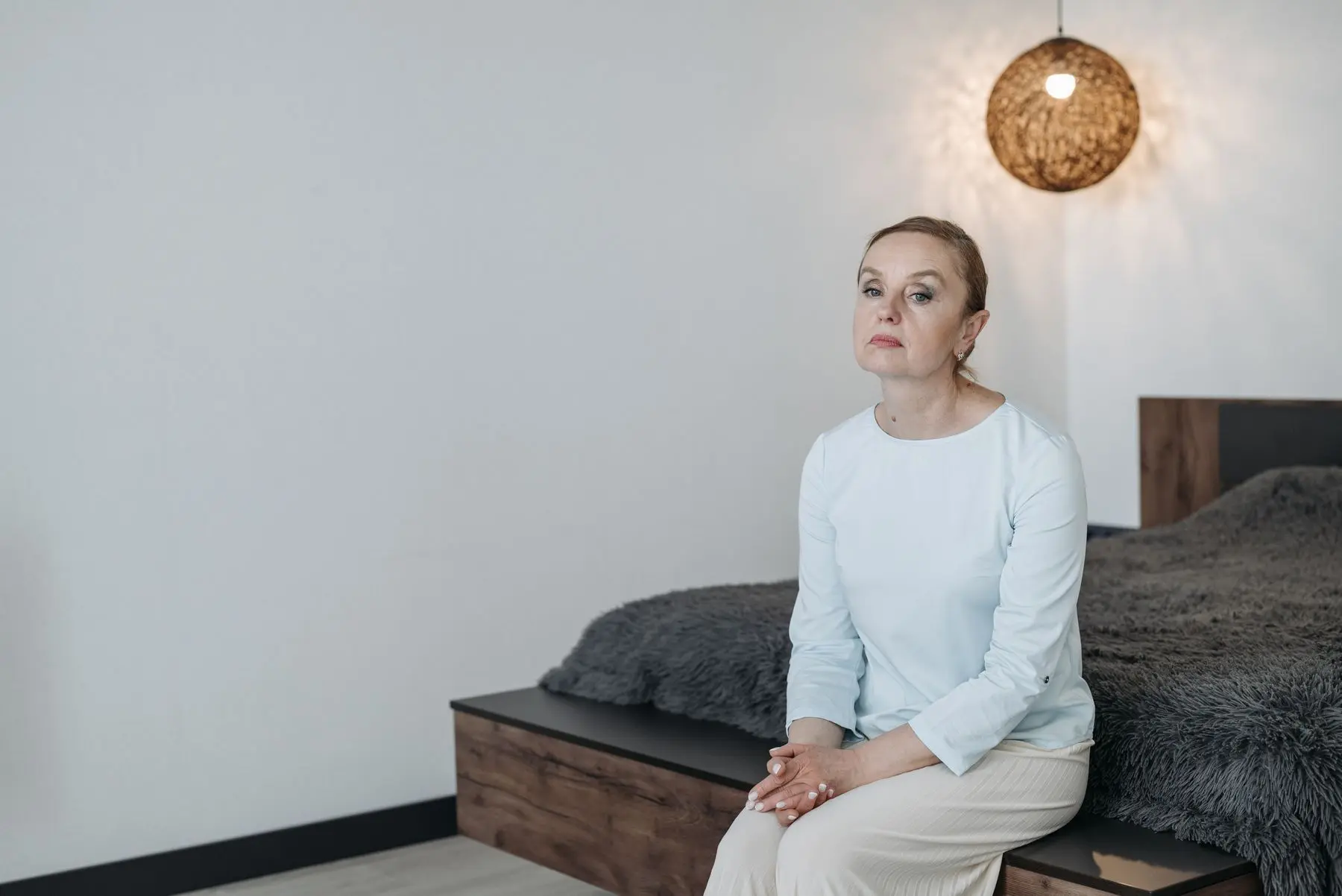 Nachdenkliche Frau sitzt auf dem Bett